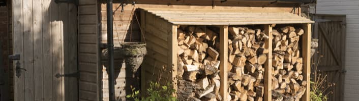 focus sur un abris de jardin contenant du bois de chauffage