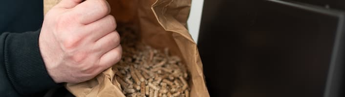 personne vidant un sac de pellets