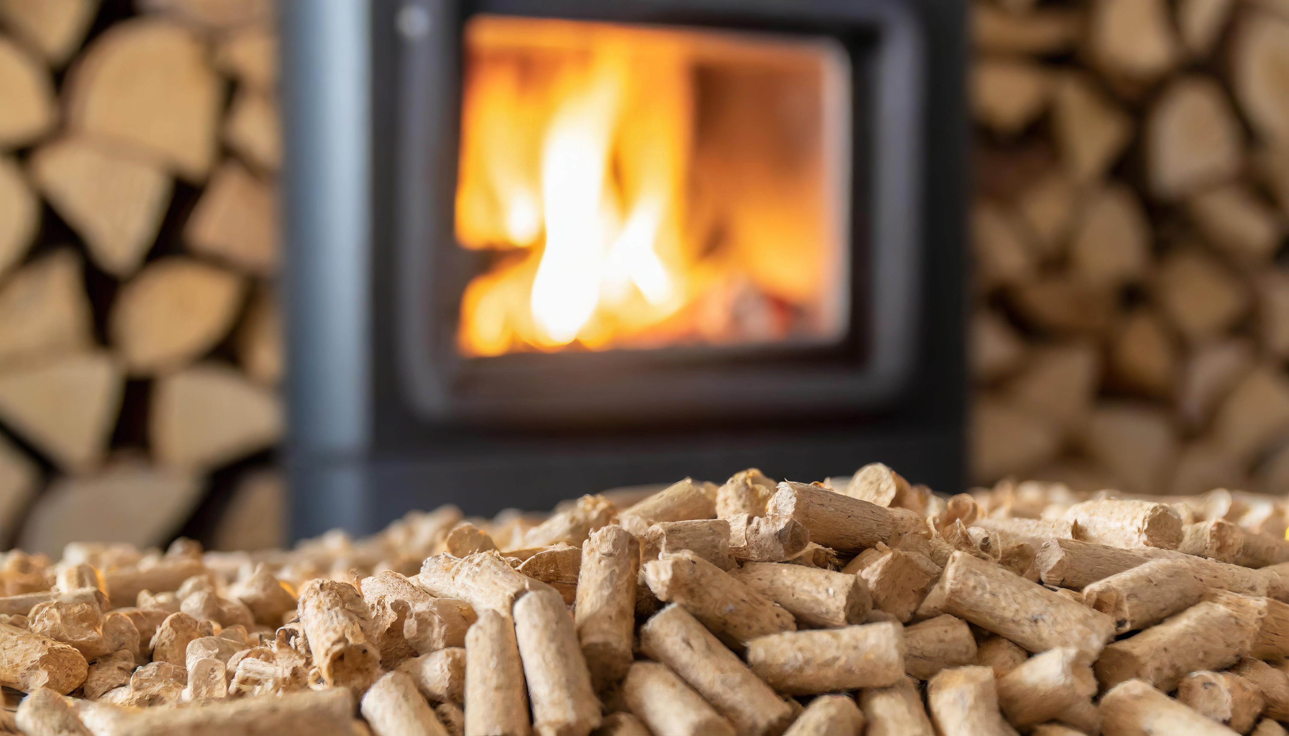 focus sur des granulés de bois et un poêle allumé en arrière plan