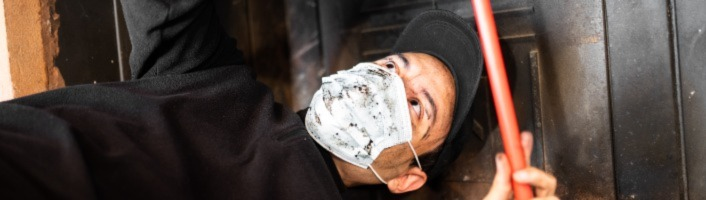 technicien ramonant avec un masque de protection