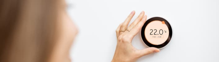 femme réglant la température du chauffage