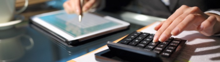personne avec une calculette et prenant des notes