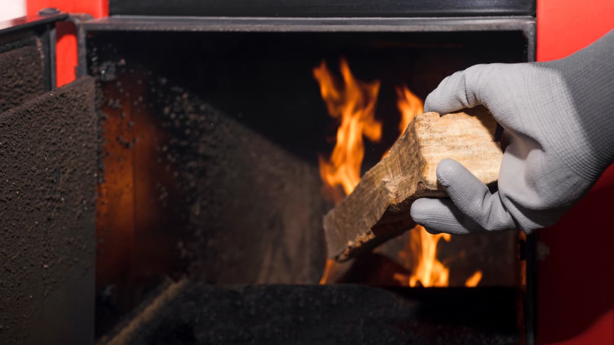 une personne alimentant en bois son chauffage