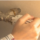 personne réglant la température d'un radiateur