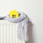 focus d'une maison jaune miniature avec une écharpe sur un radiateur