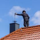 ramonage d'une sortie de cheminée sur un toit