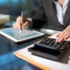 personne avec une calculette et prenant des notes