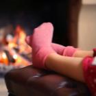 personne chauffant ses pieds avec une cheminée