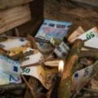 personne s'apprêtant à enflammer du bois et des billets d'euros