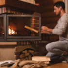 personne alimentant sa cheminée avec du bois