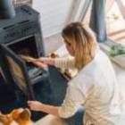 femme alimentant sa chaudière avec du bois