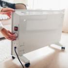 personne réglant son chauffage d'appoint
