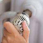 personne réglant la température d'un radiateur