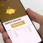 smartphone affichant souscrire et déficit foncier