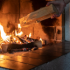 personne alimentant sa cheminée avec du bois
