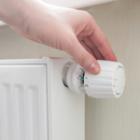 personne réglant la température d'un radiateur