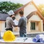 artisan de chantier montrant une maison du doigt et serrant la main d'un client