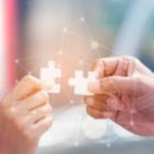 deux mains tenant une pièce de puzzle