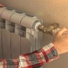 personne réglant la température d'un radiateur