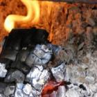 bûche consumée par une flamme entourée de cendres