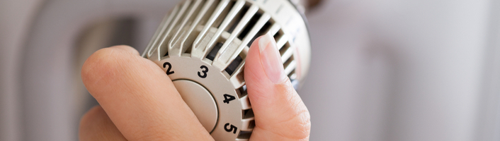 personne réglant la température d'un radiateur