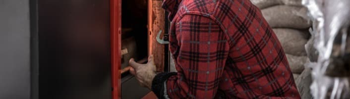 personne ouvrant une chaudière à bois