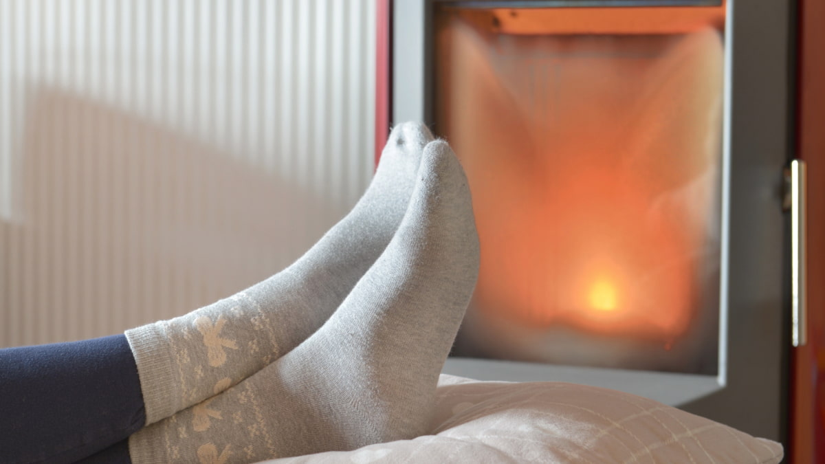 personne se prélassant devant un poêle