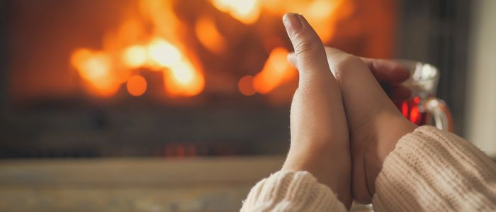 mains se chauffant devant une cheminée