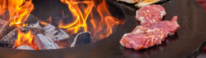 viandes cuisant sur le rebord d'un brasero