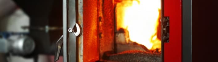 une chaudière allumée avec sa porte ouverte