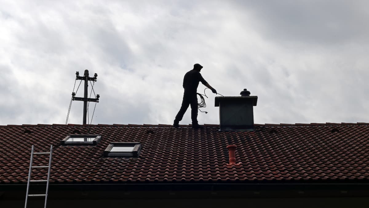 ramonage d'une sortie de cheminée sur un toit