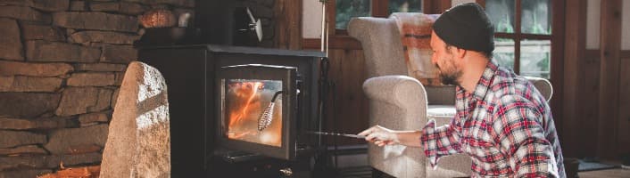 homme attisant le feu dans un poêle