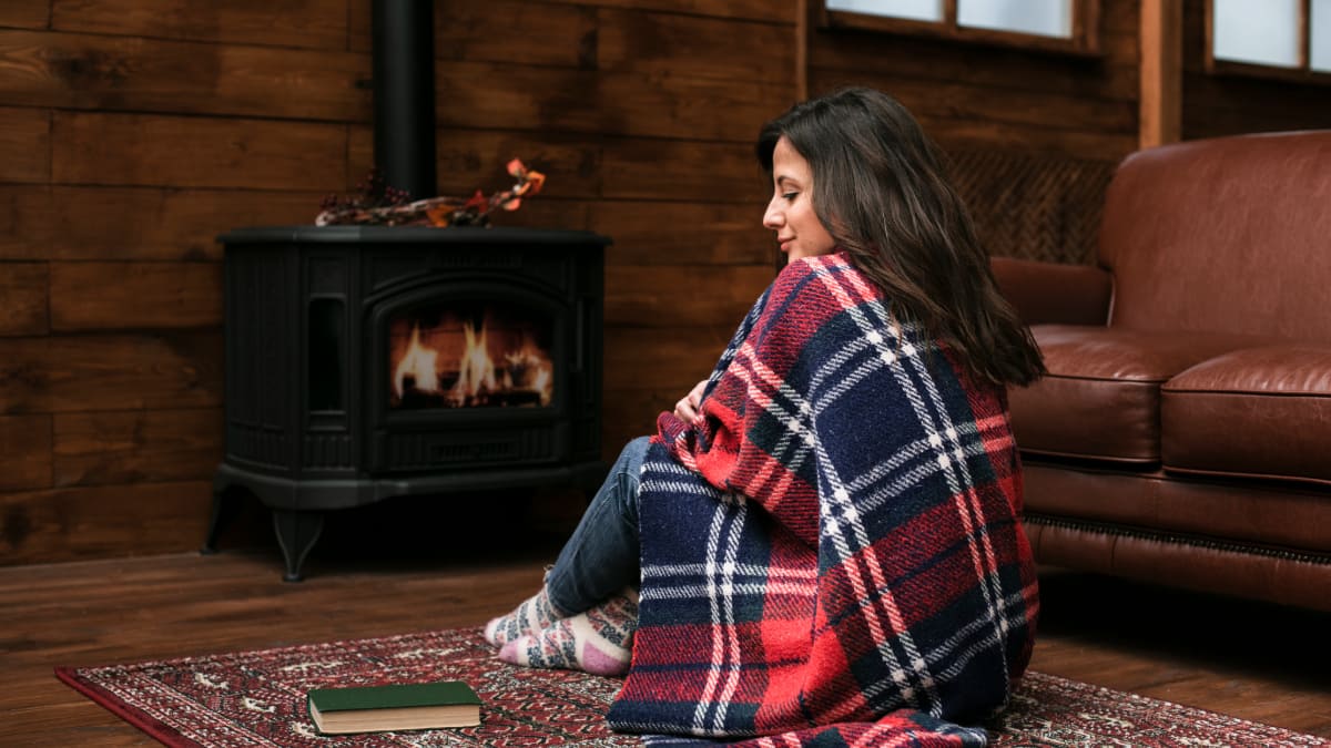 femme devant un poêle allumé