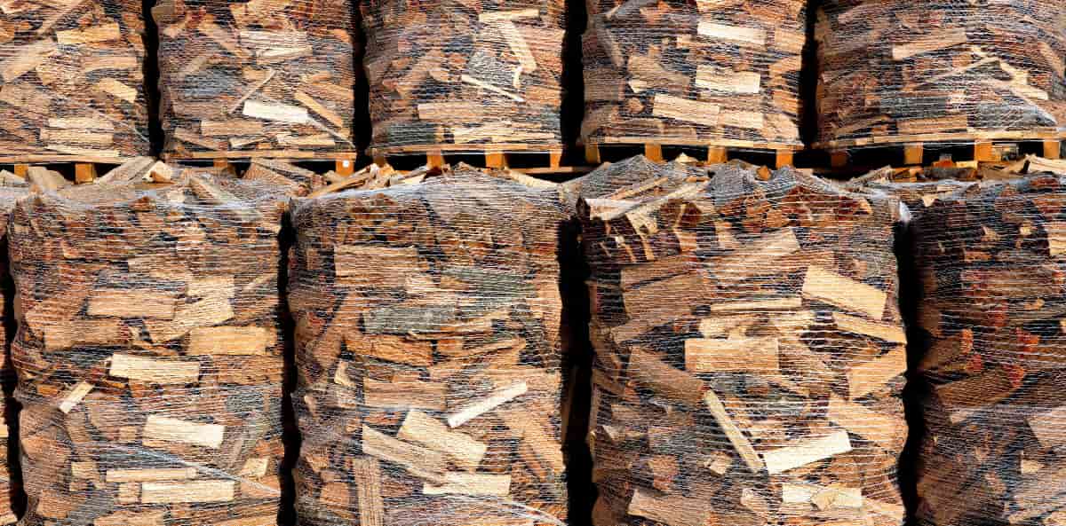alignement de plateaux soutenant des tas de bûches de bois empaquetées