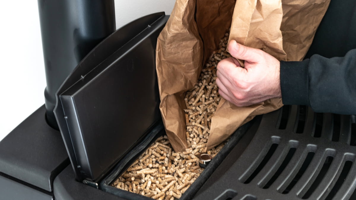 personne remplissant son silo à pellets