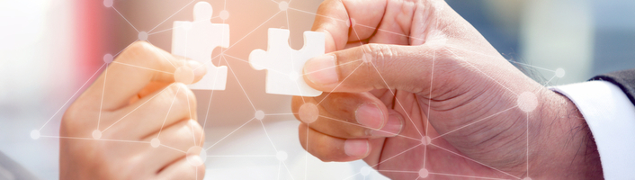 deux mains tenant une pièce de puzzle
