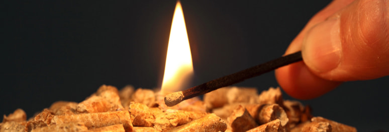 personne brûlant à l'allumette du pellets de bois