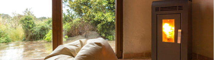 salon avec fenêtre panoramique au milieu un sofa devant une cheminée