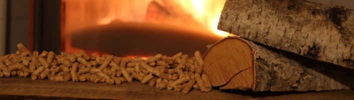 focus sur deux bûches et un tas de pellets de bois