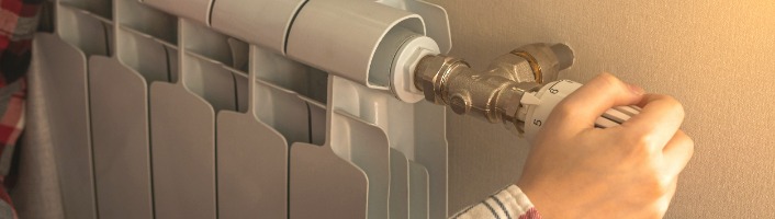 personne réglant la température d'un radiateur