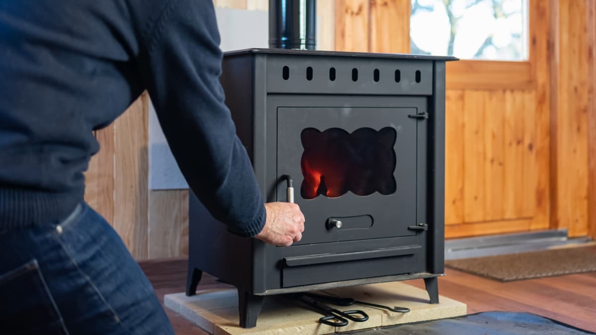 personne ouvrant la porte de son poêle