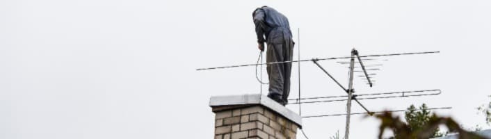 ramonage d'une sortie de cheminée sur un toit